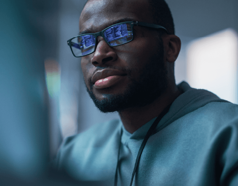 Man wearing glasses looking at a computer screen.